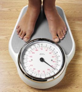 Woman's feet standing on weight scales