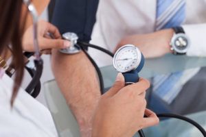 man having a blood pressure check at doctors surgery